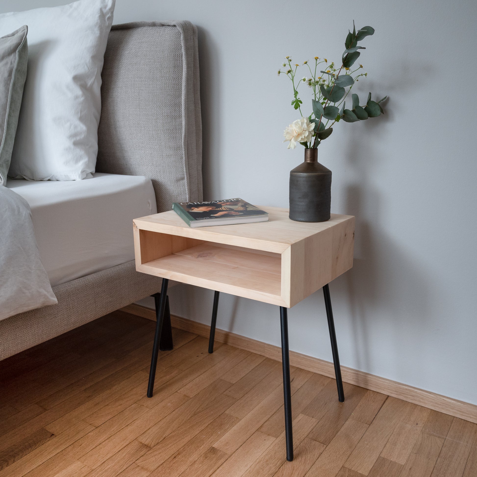 Zirbenholz Nachttisch GREIN neben Bett im Schlafzimmer mit natürlichem Holzdesign